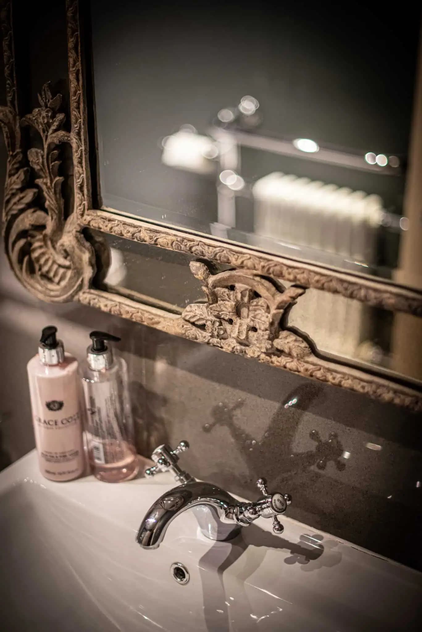 Bathroom basin and antique mirror inside Luxurious Home.