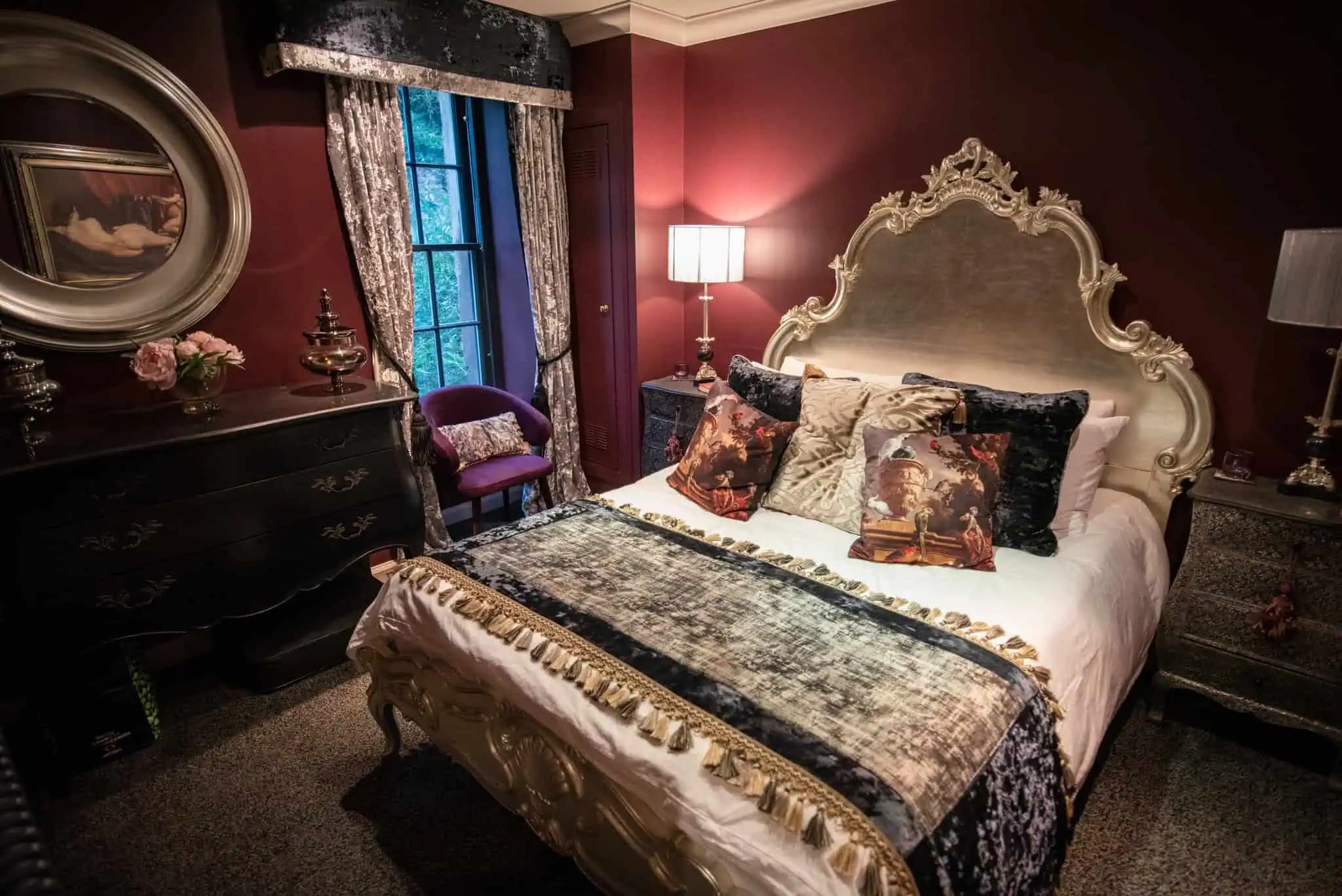 Burgundy bedroom with an ornate bed inside Luxurious Home.