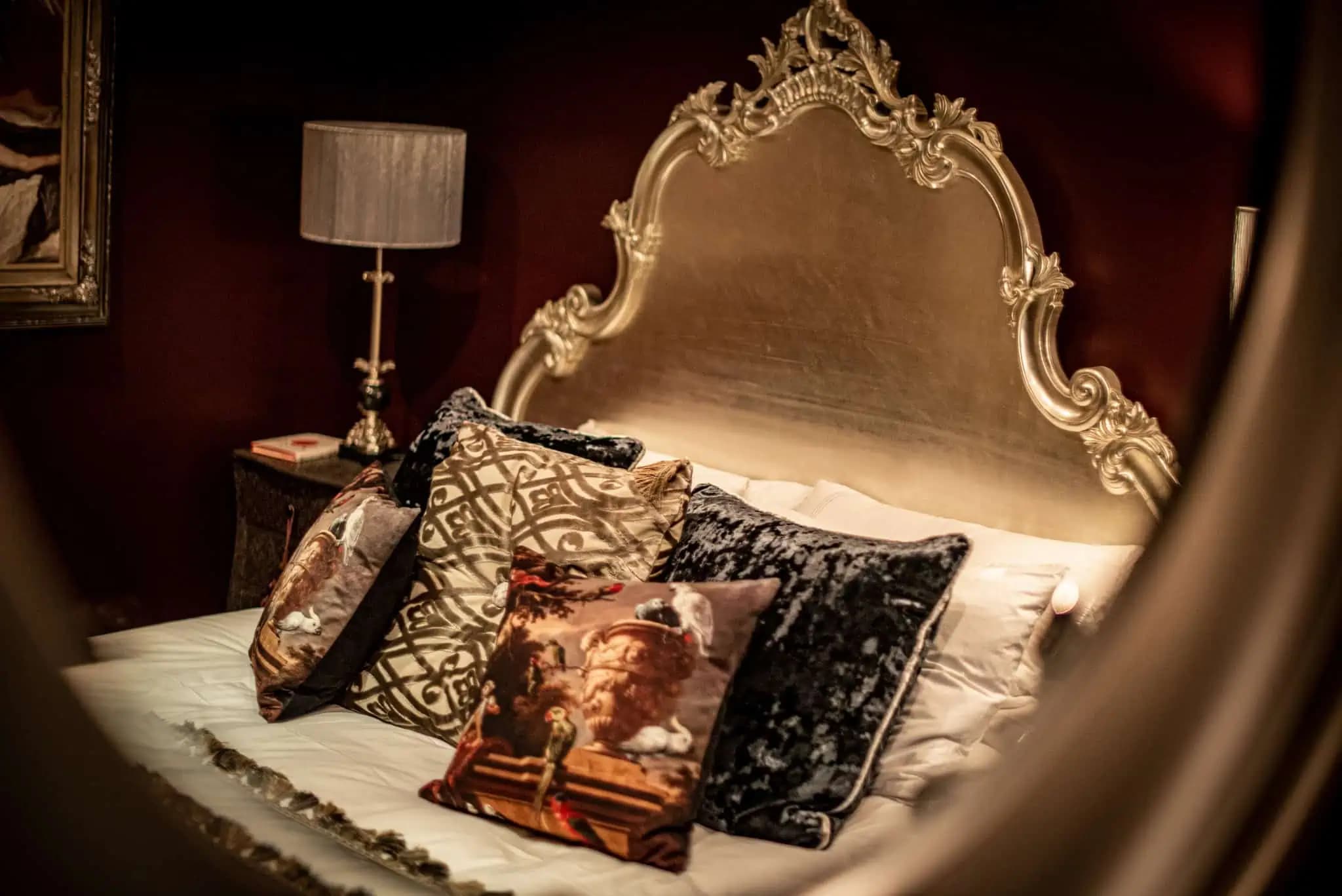 Ornate bed and cushions inside Luxurious Home.