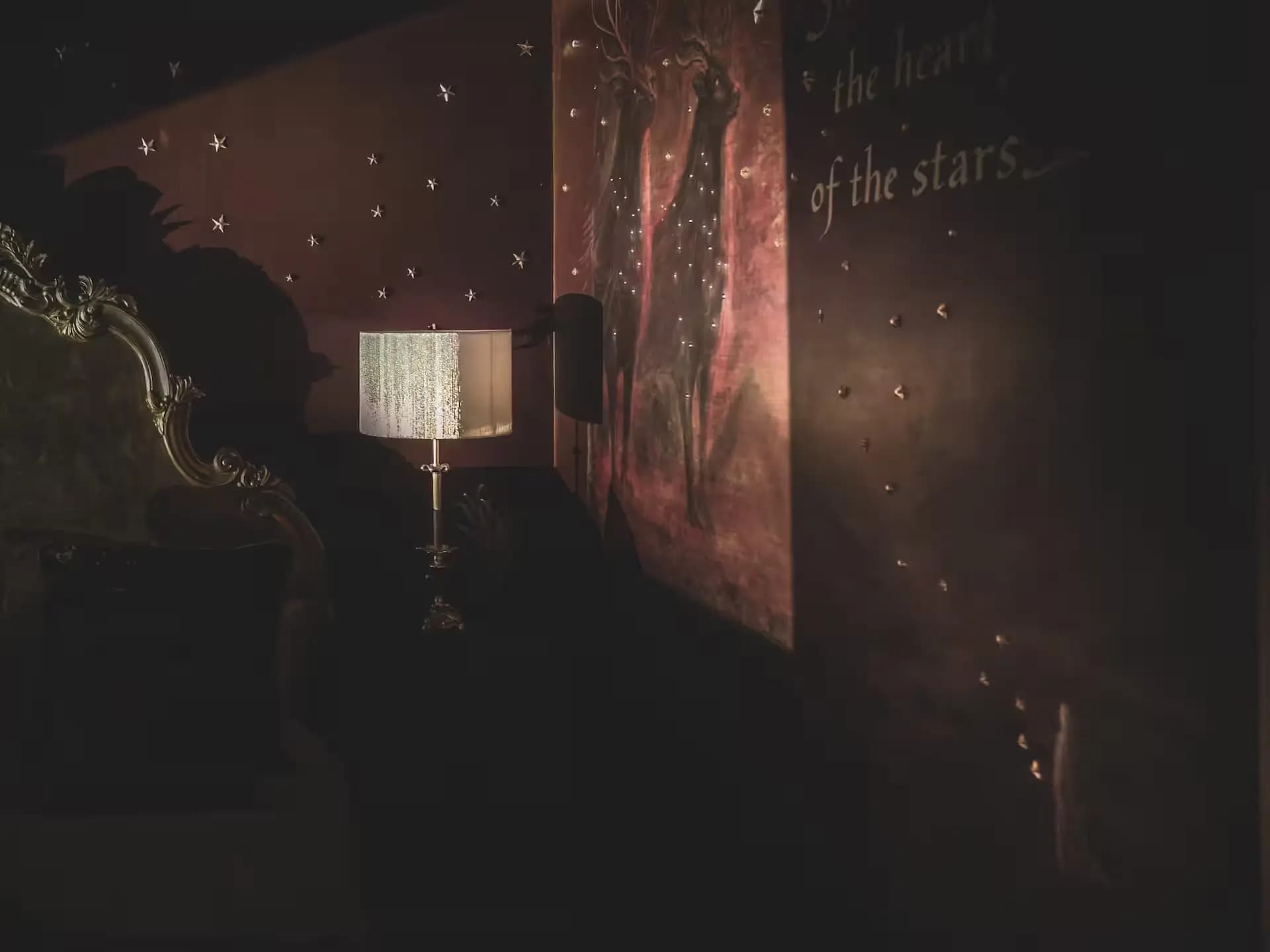 Bedside lamp against a starry burgundy wall inside Luxurious Home.