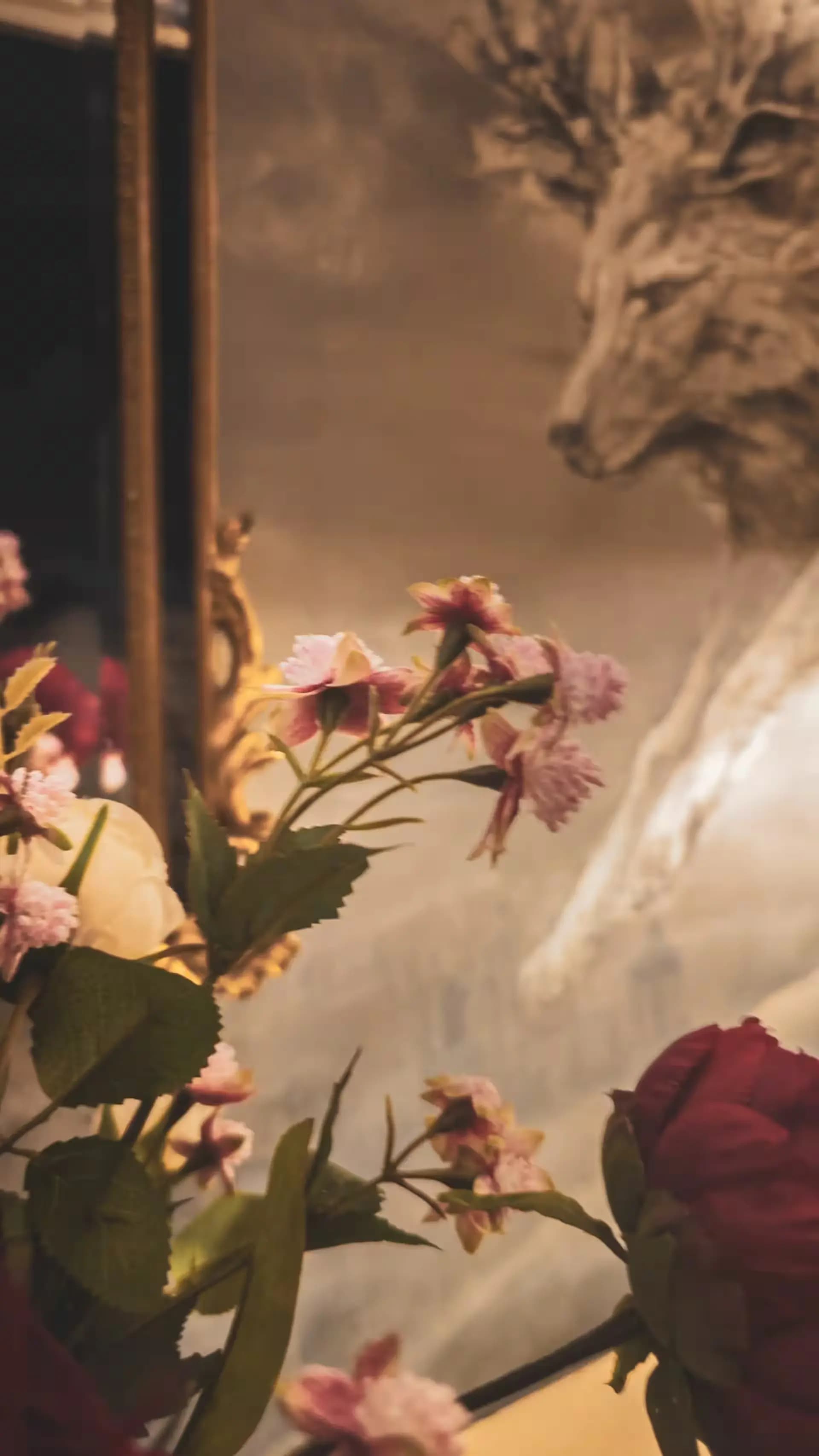 Flowers reflected beside a gold mirror inside Luxurious Home.