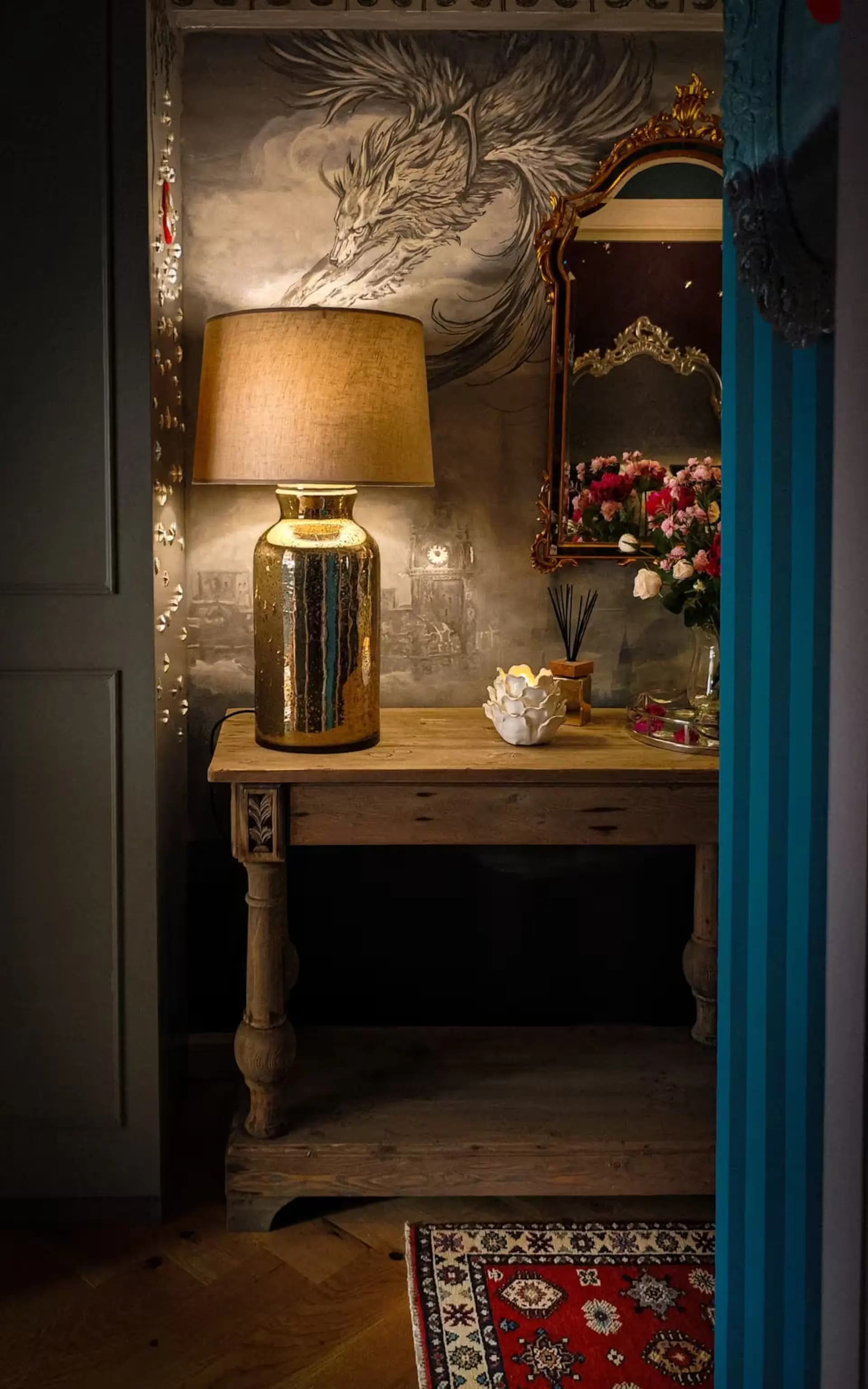 Lamp and console table with mural detail inside Luxurious Home.