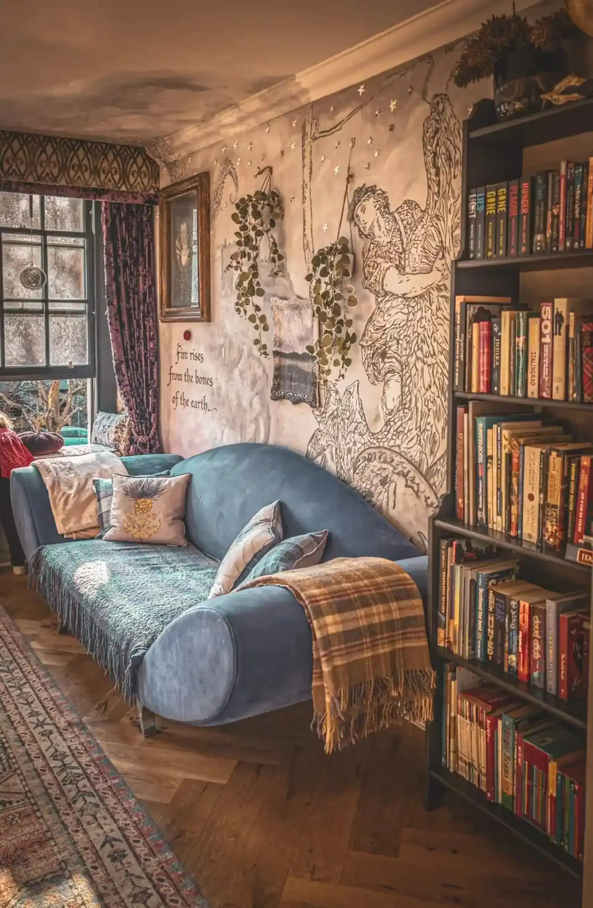 Blue sofa and bookcase beside a mural wall inside Luxurious Home.