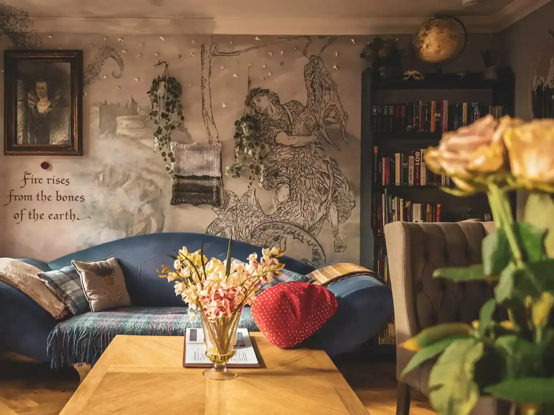 Portrait artwork and writing above a blue sofa inside Luxurious Home.