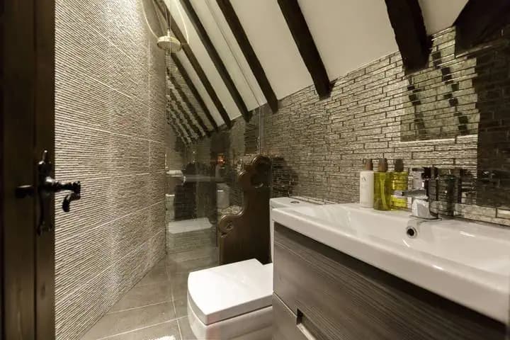 Shower room with exposed beams inside The Outlander Lodge.