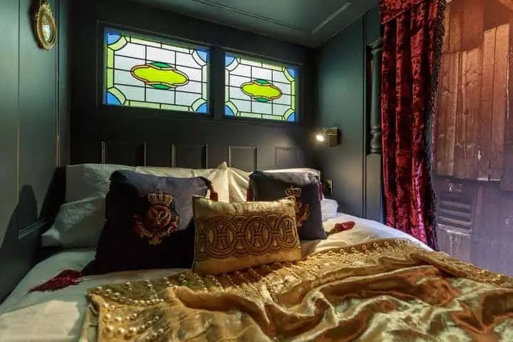 Box bed with velvet drapes inside The Outlander Lodge.