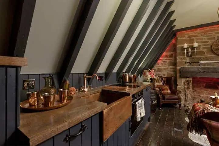 Kitchen with dark beams and copper details inside The Outlander Lodge.