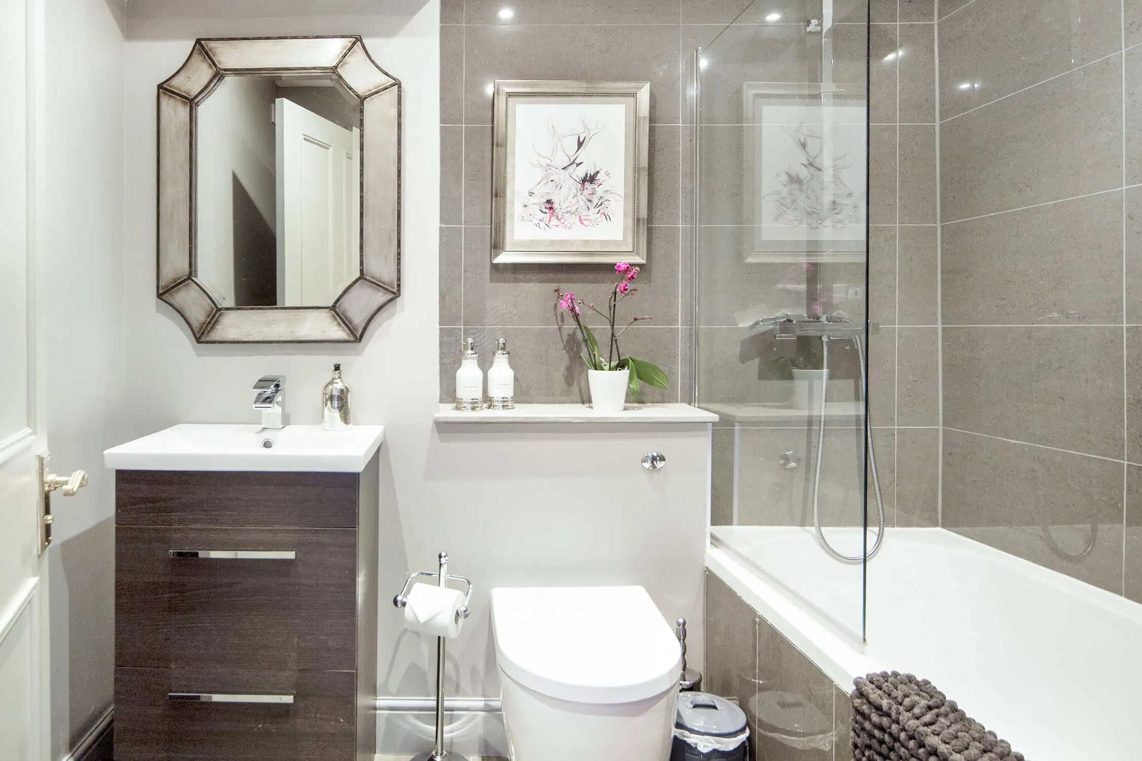Bathroom with bath and shower screen inside Romantic Stay.